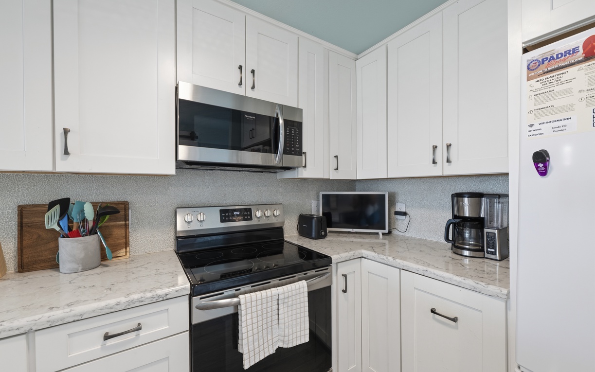 Your fully equipped kitchen features modern stainless appliances, gleaming marble countertops, and crisp white cabinetry—everything you need to prepare delicious home-cooked meals during your stay.