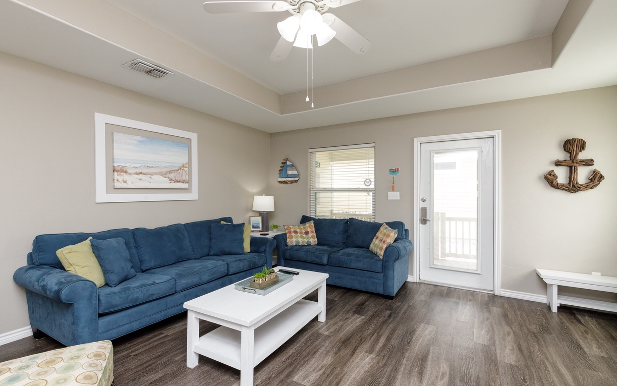 Relax in your spacious living room with plush navy sectional sofa and coastal charm throughout.
