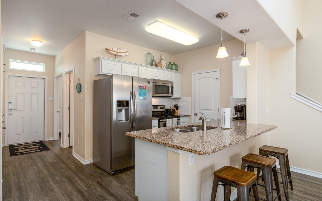 Your spacious kitchen features granite counters, stainless appliances, and a breakfast bar perfect for morning coffee or casual meals.
