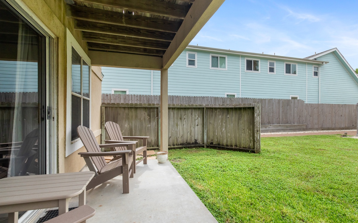 Step onto your private covered patio where comfortable chairs await your morning coffee or evening relaxation in the peaceful backyard.