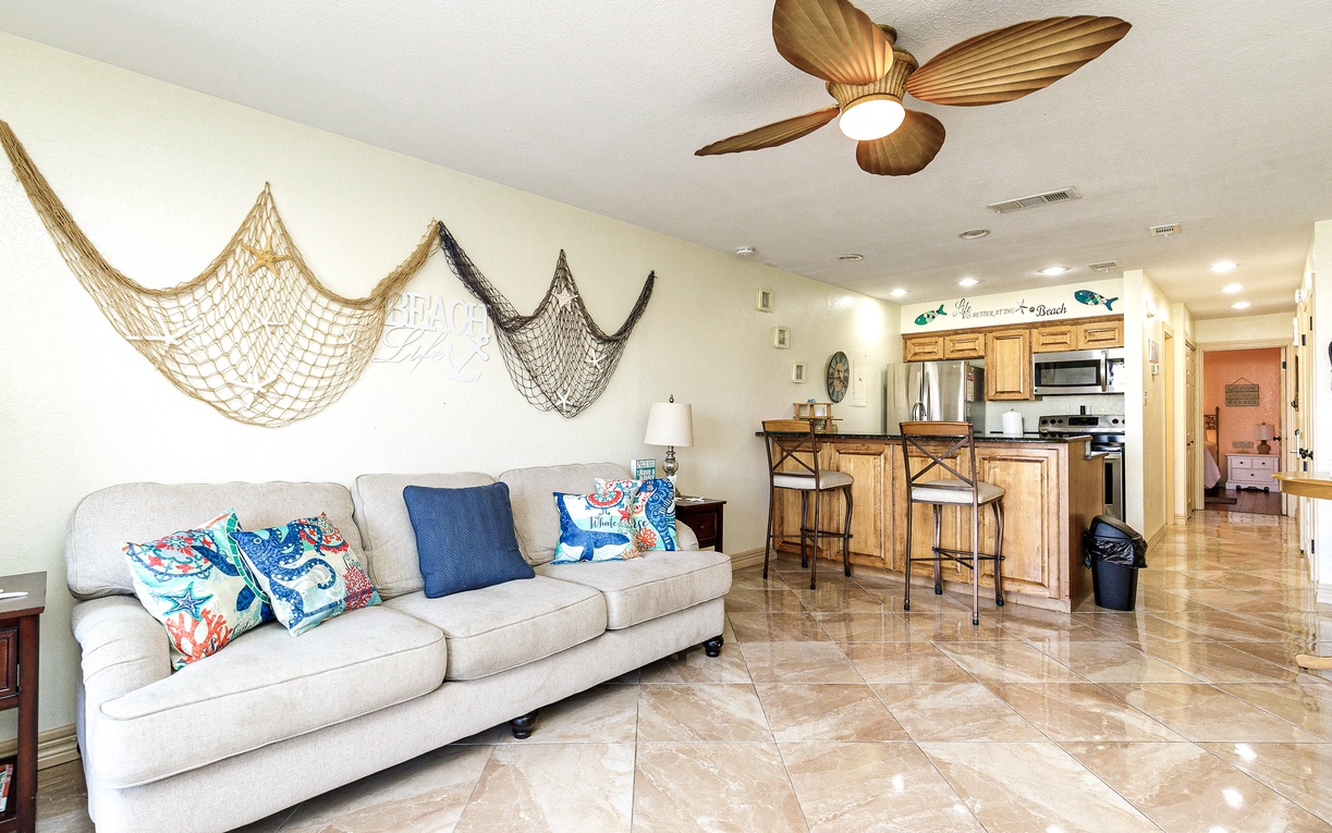 Sink into your coastal retreat where nautical nets and tropical fans create the perfect beach vibe for relaxing evenings.