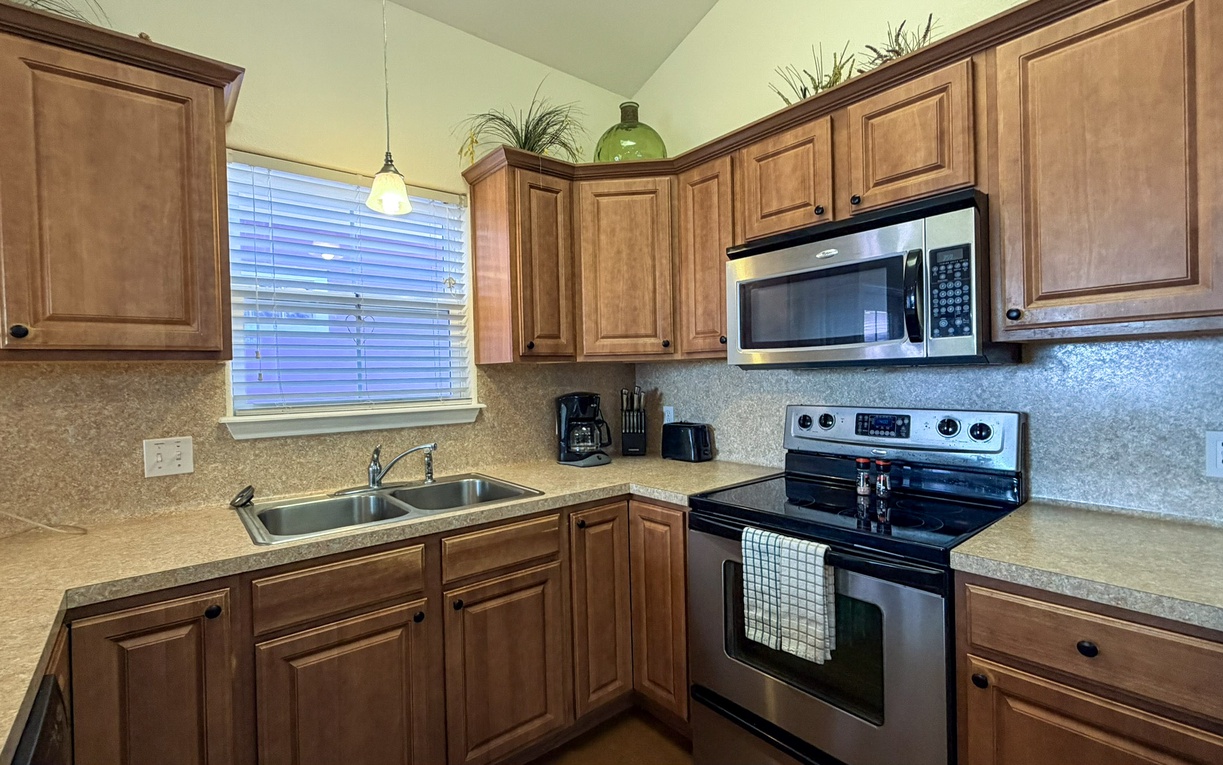 Cook memorable meals in your fully-equipped kitchen featuring warm wood cabinets, granite countertops, and modern appliances perfect for culinary adventures.