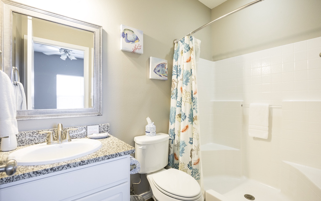 Refresh in your coastal-themed bathroom with granite countertops, pristine shower, and ocean-inspired artwork creating a spa-like sanctuary.