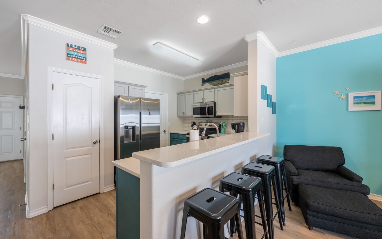 Your bright kitchen opens to a cozy living space where you can prepare meals and relax after beach days.