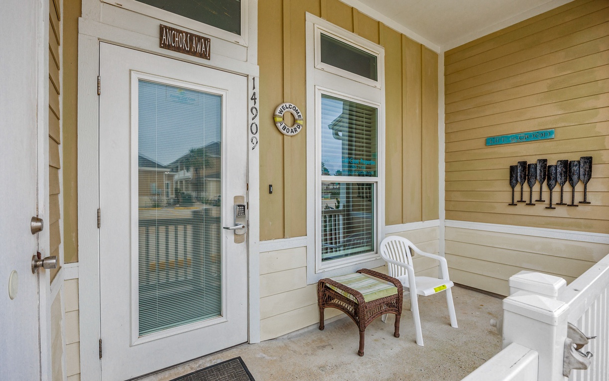 Your welcoming front porch offers a peaceful spot to enjoy morning coffee with charming coastal details and comfortable seating.