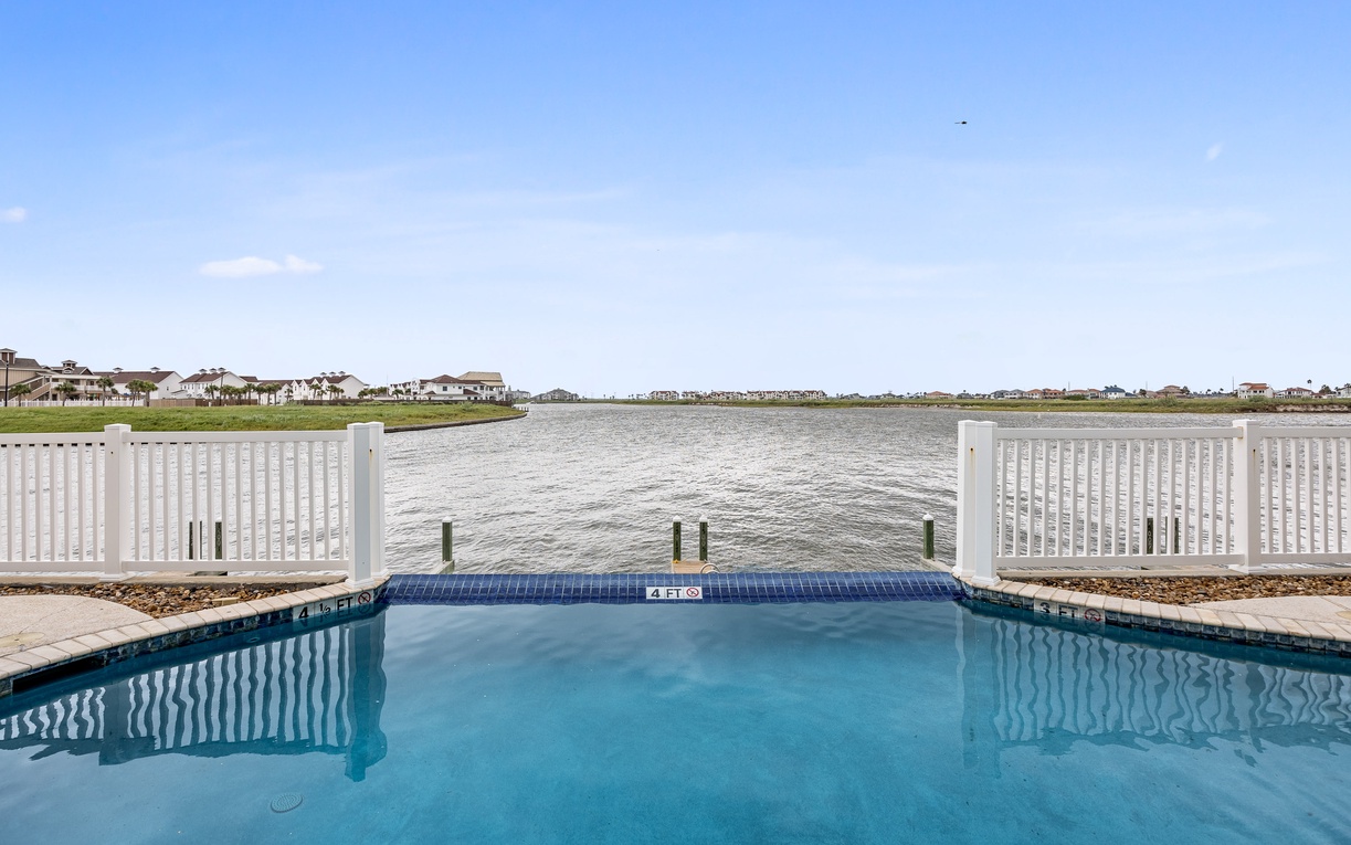 Private waterfront pool with stunning bay views and coastal community backdrop.