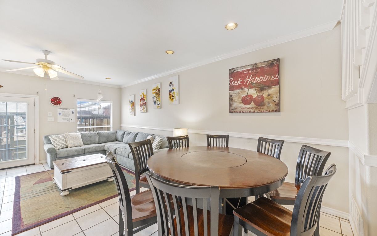Gather around the spacious dining table for memorable meals while relaxing on the comfortable sectional sofa nearby.
