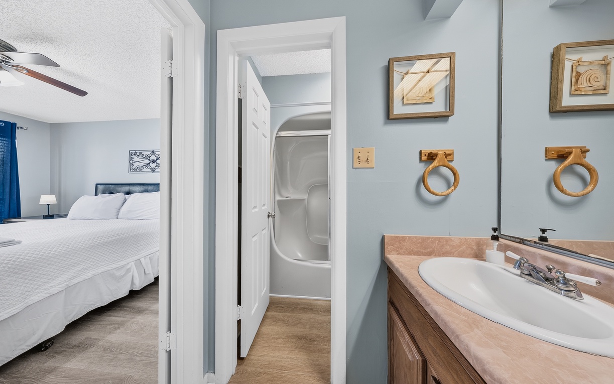 Your private ensuite connects seamlessly to your bedroom, featuring calming coastal colors and thoughtful touches like natural wood accents that add warmth to your daily routine.