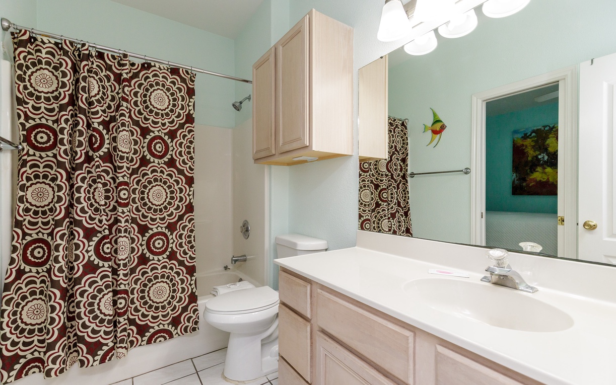 Step into your private bathroom featuring a spacious vanity, ample storage, and cheerful décor that makes morning routines feel like a treat.