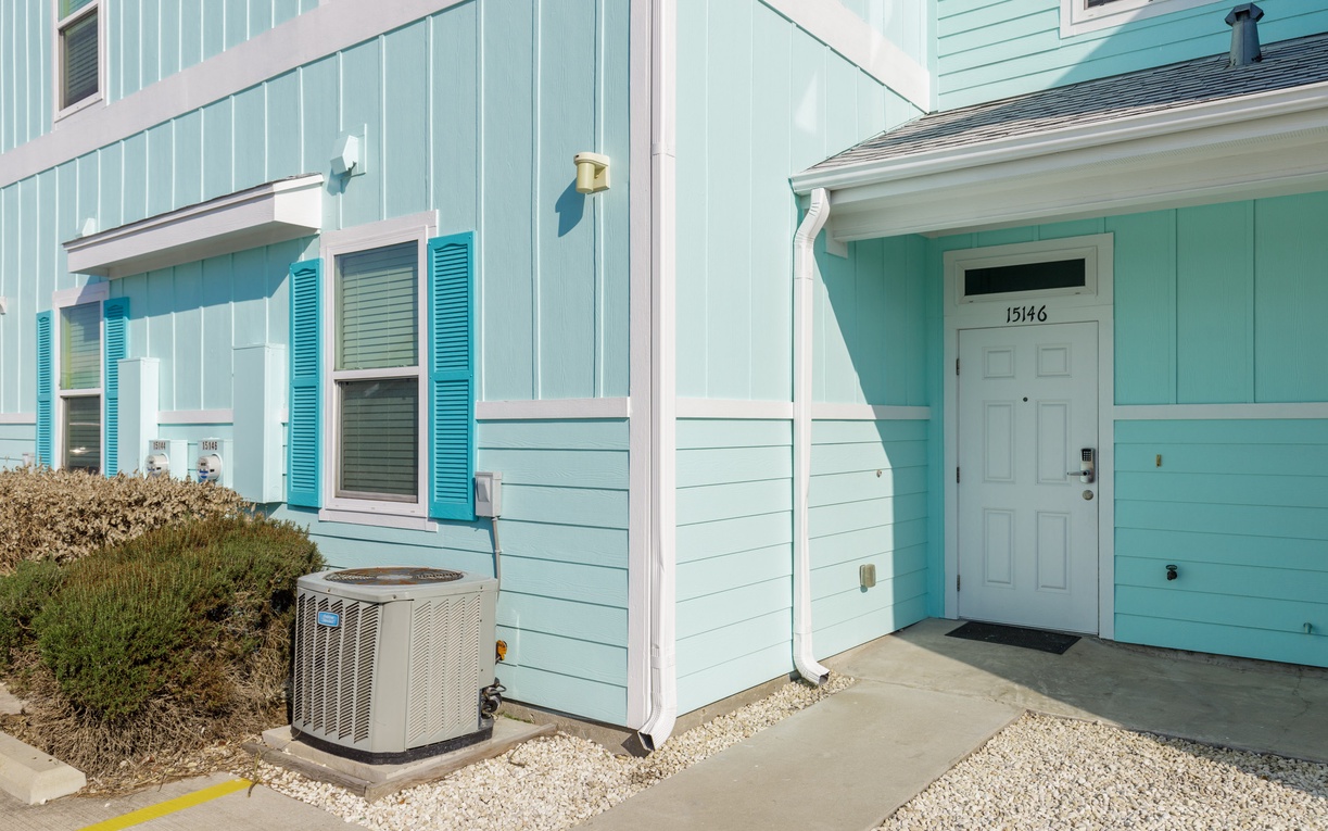 Charming coastal property with vibrant turquoise siding and white trim creates a welcoming beachside atmosphere at unit 15146.