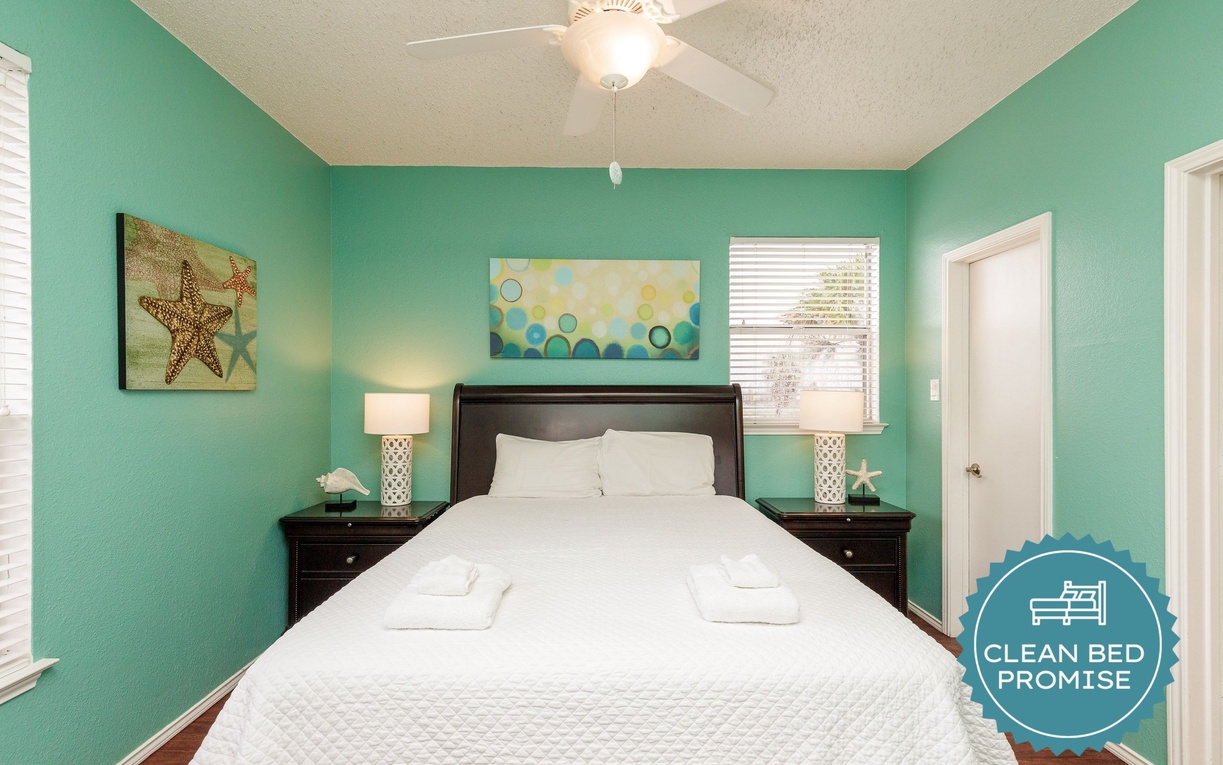 Your coastal bedroom offers a peaceful retreat with cheerful aqua walls, comfortable bedding, and charming seaside artwork to help you unwind.