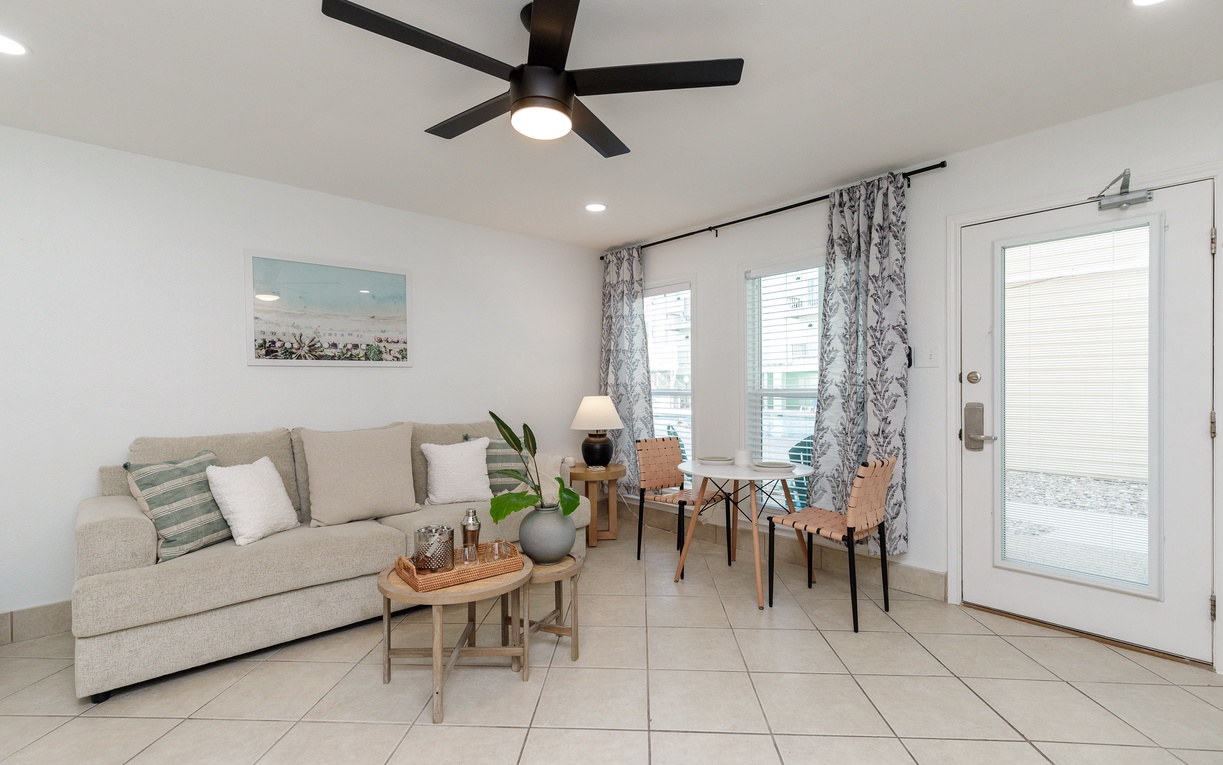 Unwind in your bright, modern living room with cozy seating, stylish decor, and a ceiling fan to keep you comfortable.