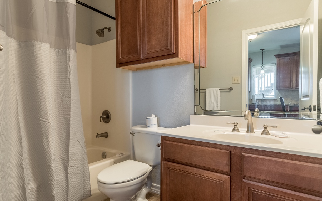Your private bathroom offers classic comfort with rich wood cabinetry, granite counters, and a relaxing tub-shower combo for unwinding after adventures.