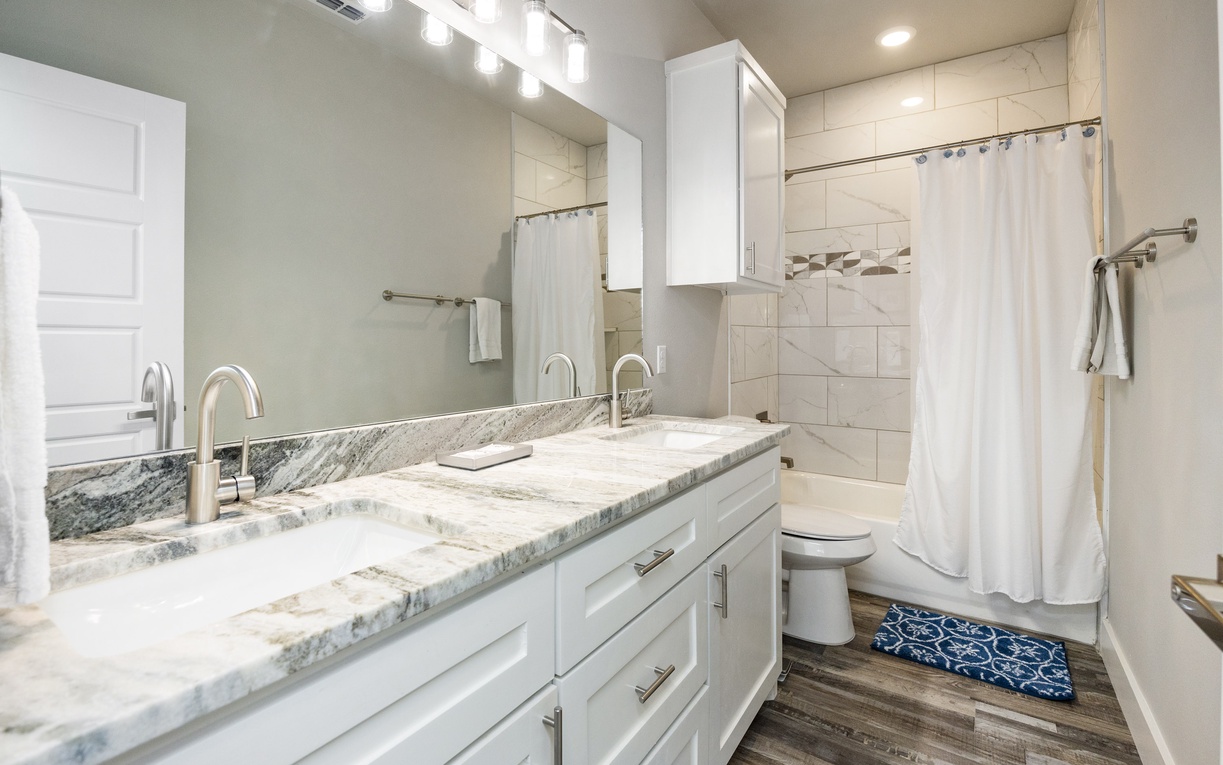 Step into your pristine bathroom featuring dual sinks with elegant marble countertops, perfect for your morning routine in this stylishly appointed space.