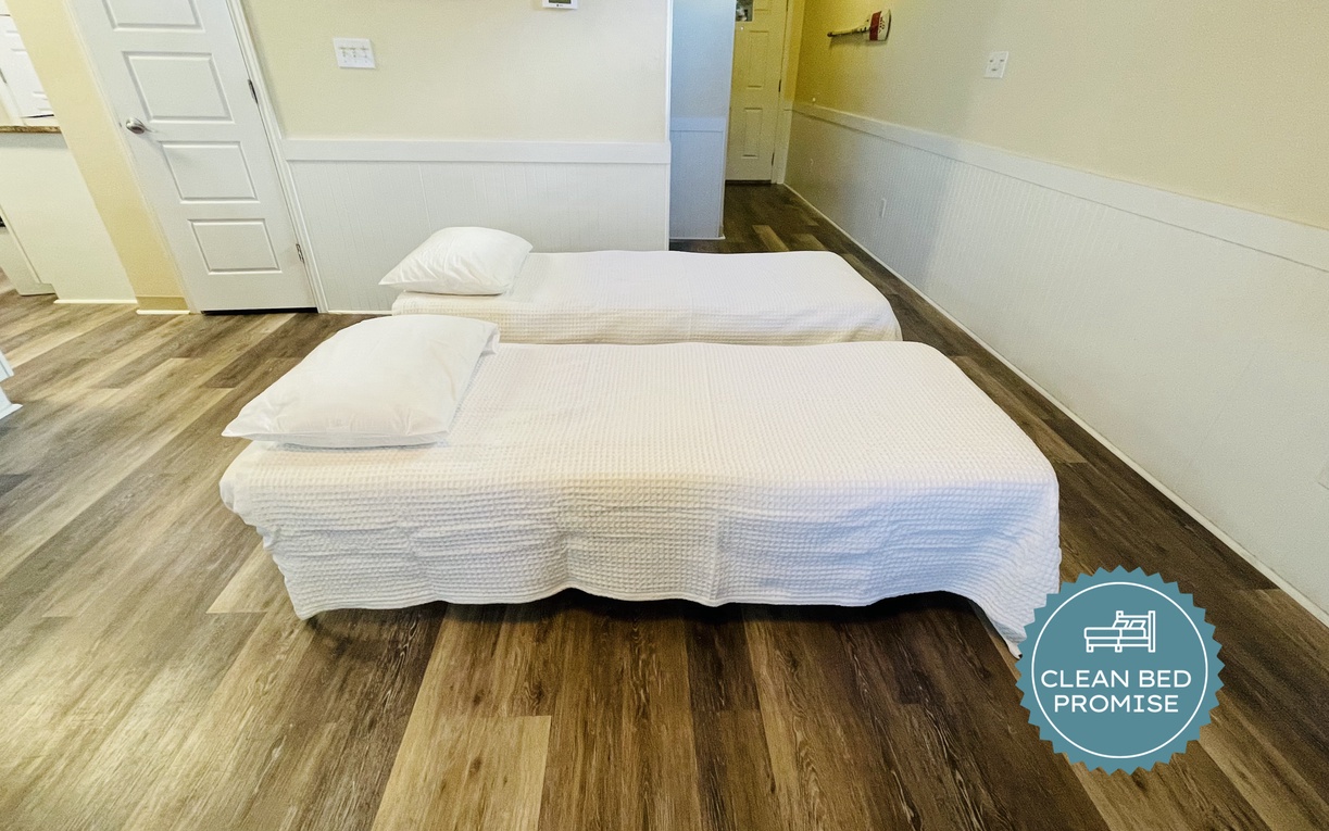 Sink into your comfortable twin beds with crisp linens after exploring the area. Hardwood floors add warmth to your bright, welcoming room.