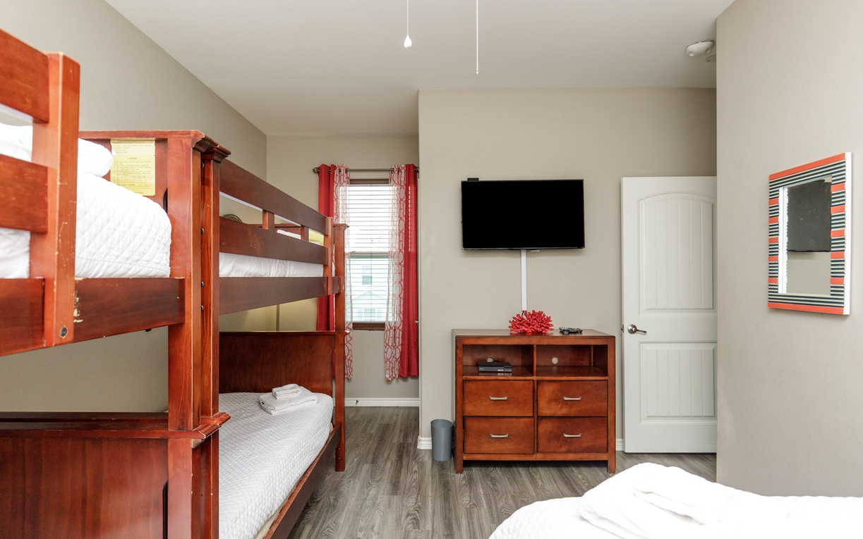 Perfect for families, your spacious bedroom features bunk beds and comfortable furnishings with warm wood tones and cheerful touches.