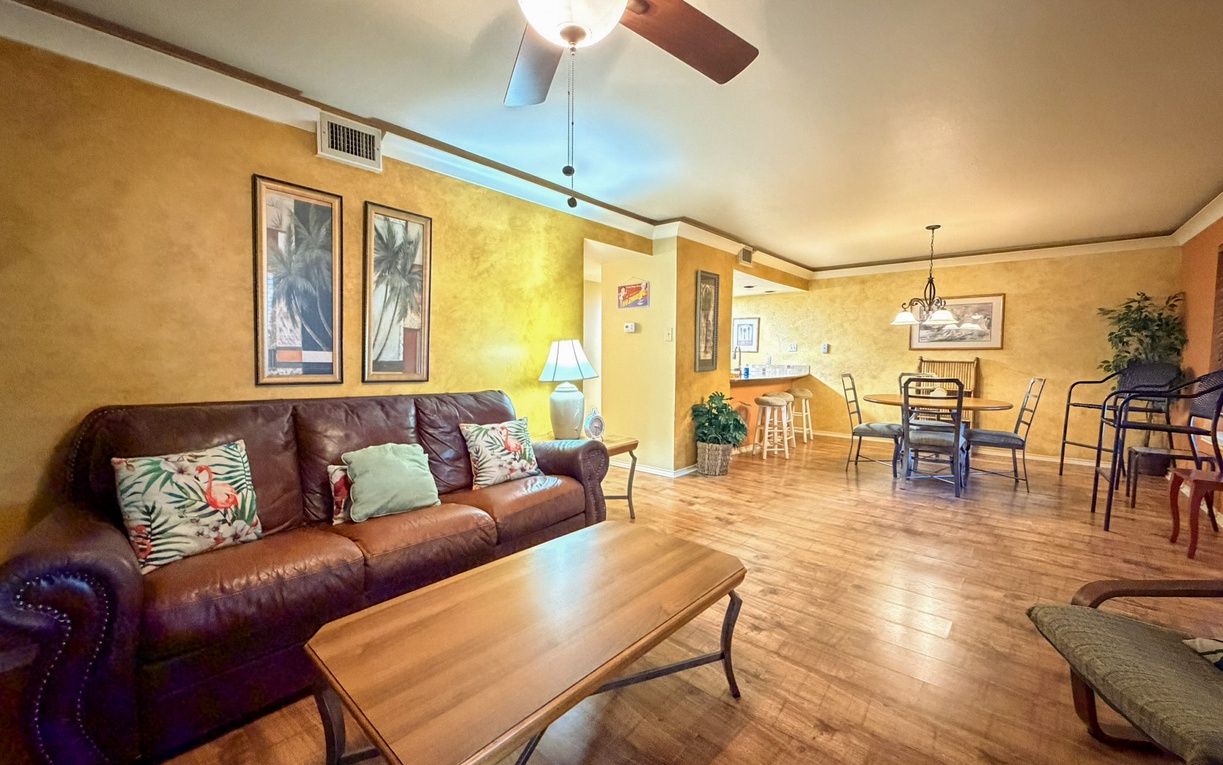 Relax in your spacious living room with comfortable leather seating, tropical décor, and an open layout connecting to your dining area.