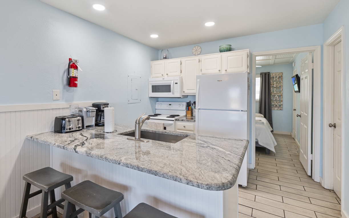 Your fully-equipped kitchen features granite counters, modern appliances, and a breakfast bar perfect for morning coffee and meal prep.