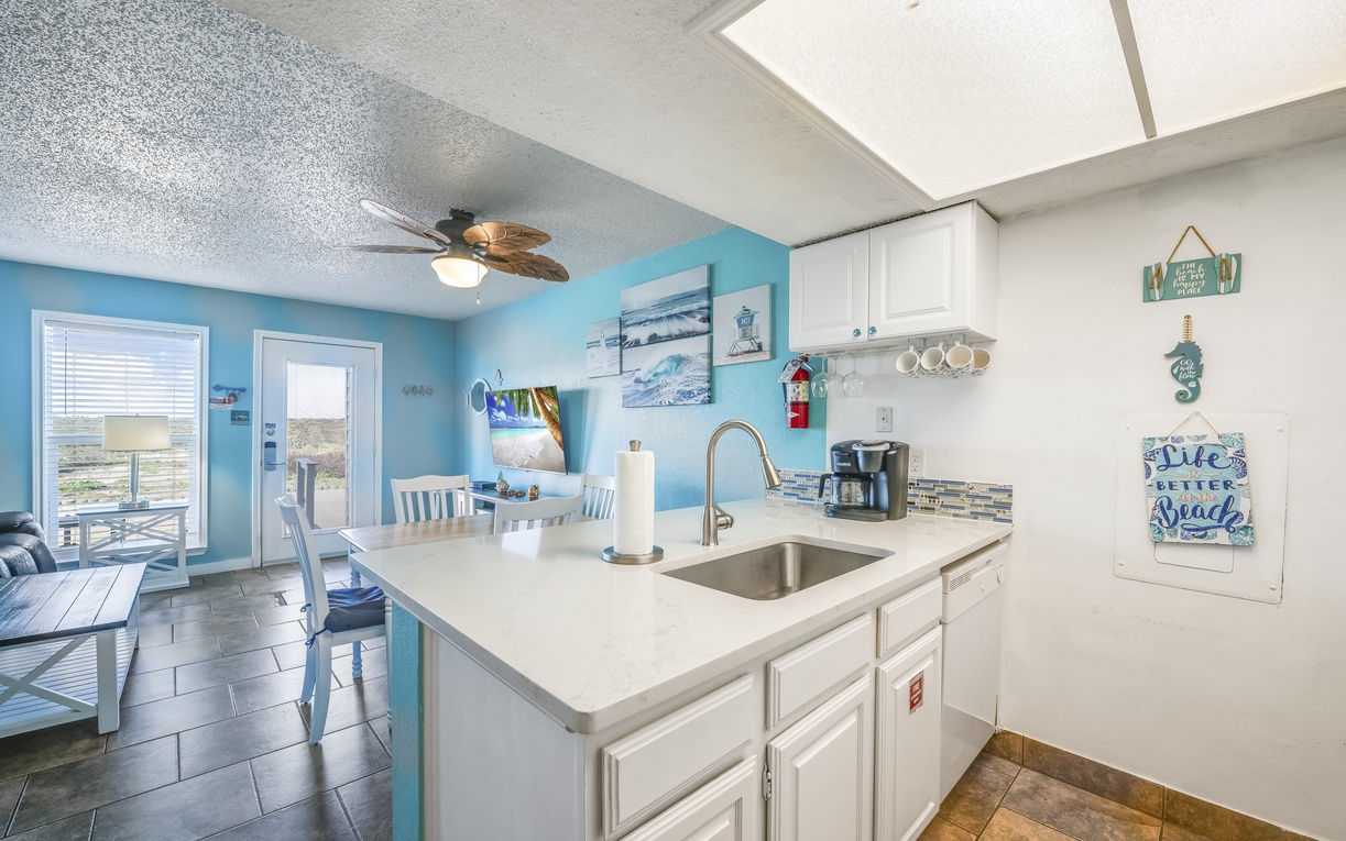 Bright, breezy kitchen with coastal charm—your coffee maker awaits each morning, and those ocean-themed touches remind you you're on vacation from the moment you wake up.