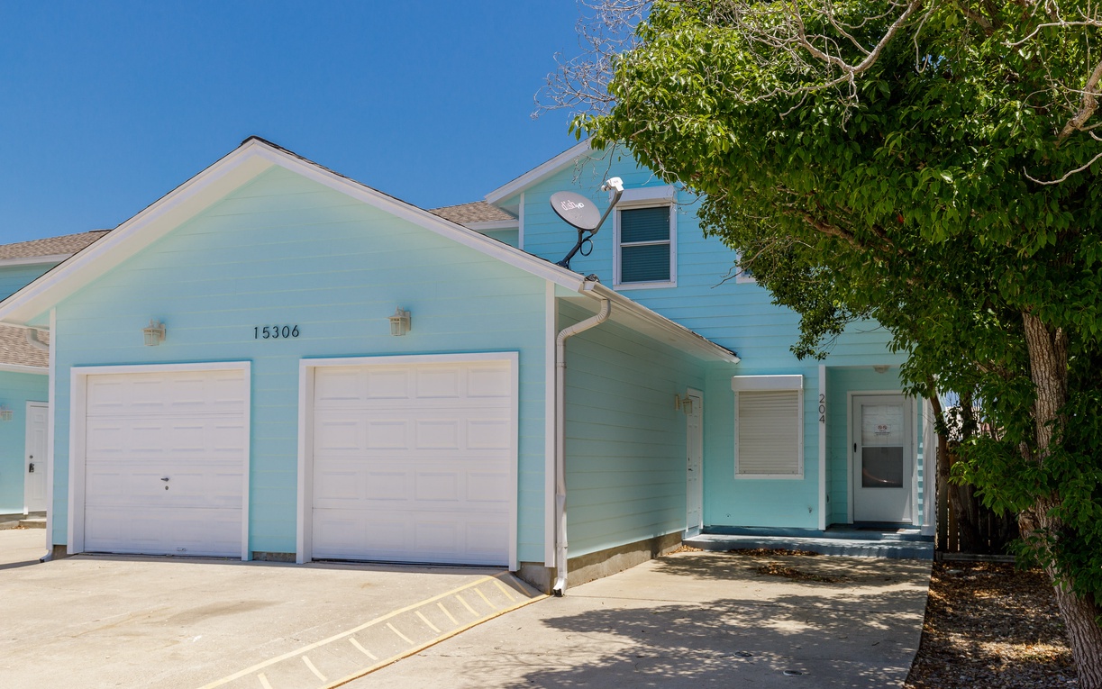 Charming turquoise beach townhome nestled under mature shade trees.