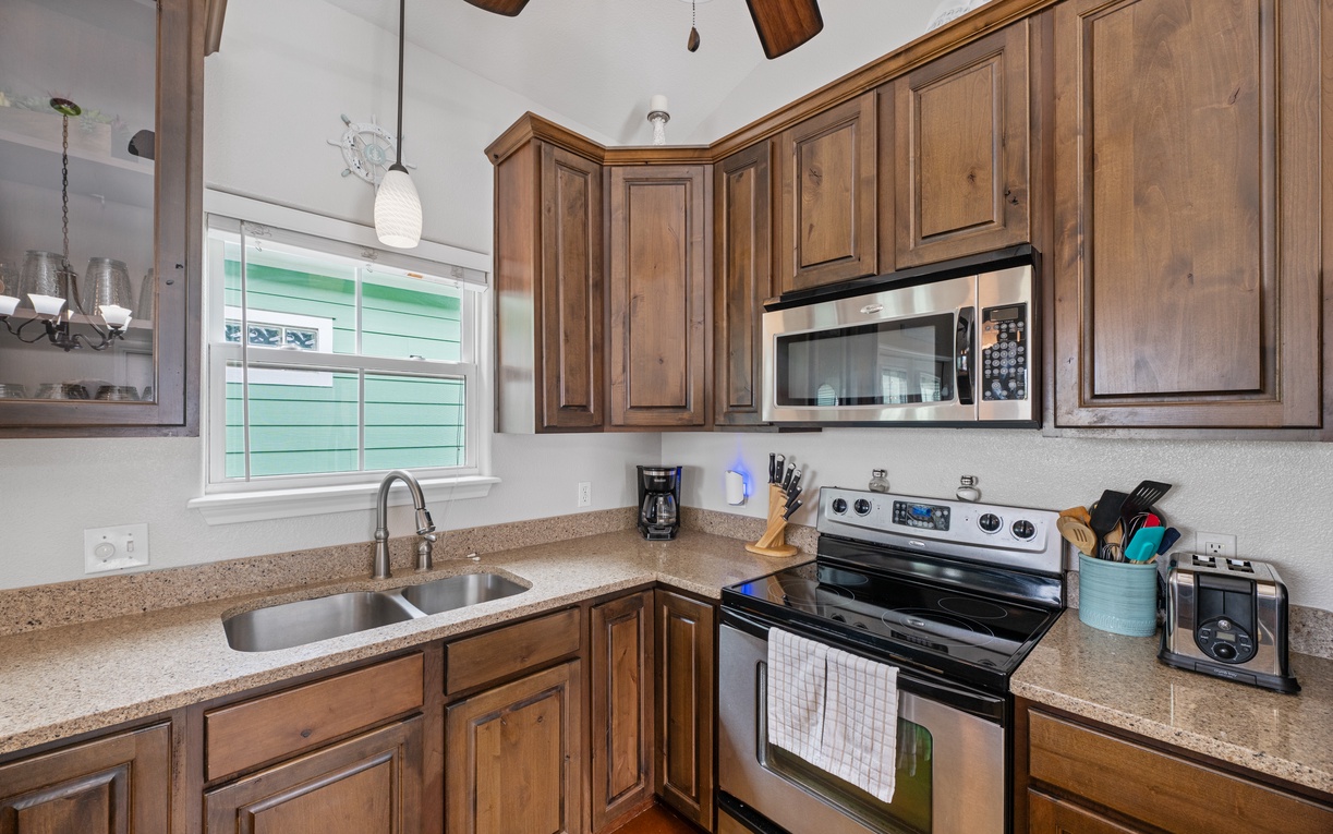 Your fully equipped kitchen features warm wood cabinetry, granite counters, and modern appliances for preparing memorable meals during your stay.