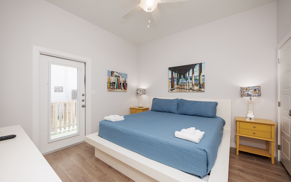 Sink into your comfortable blue bedding in this bright, modern bedroom featuring city views and thoughtful touches like fresh towels.