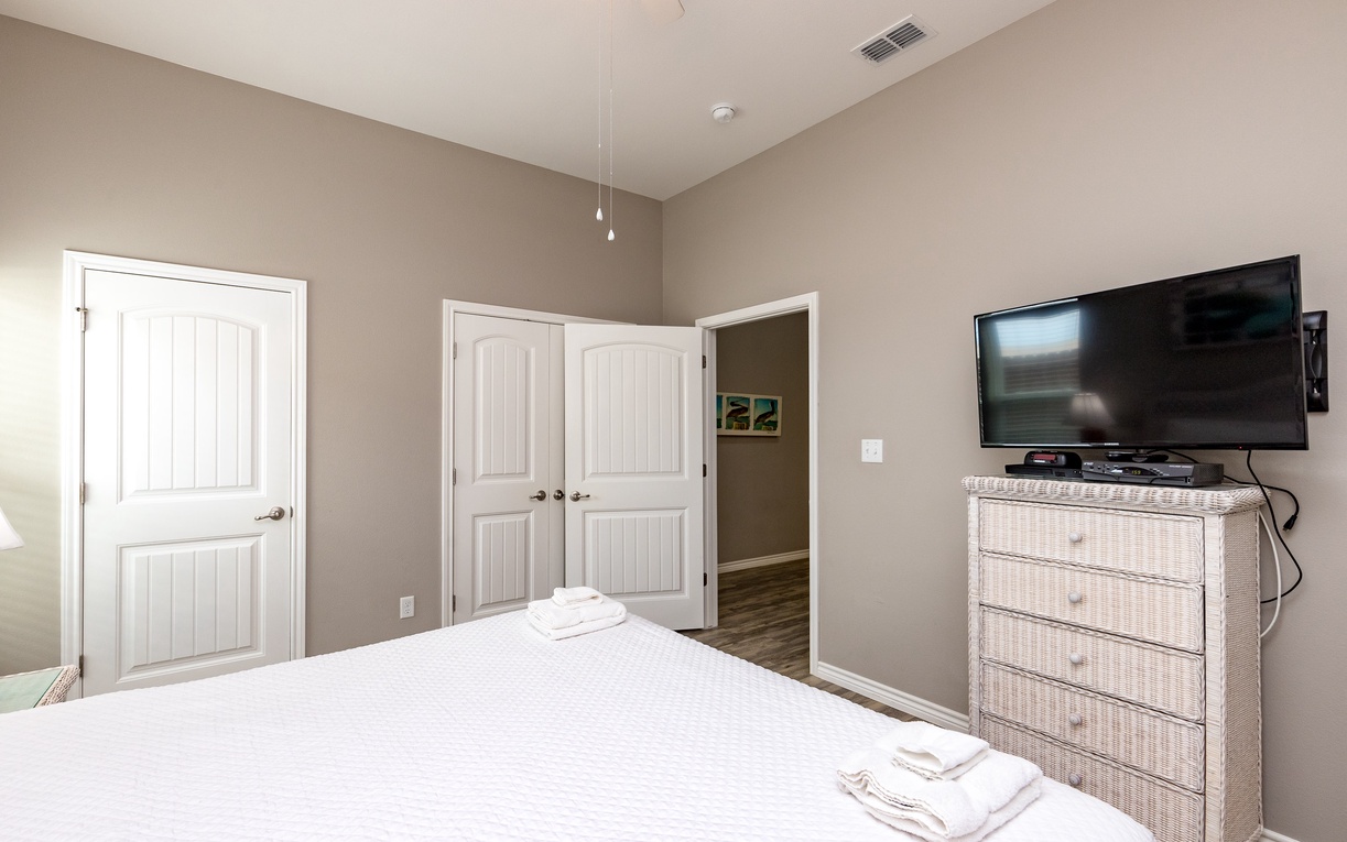 Unwind in your peaceful bedroom featuring a comfortable bed, modern TV, and thoughtful furnishings designed for ultimate relaxation.