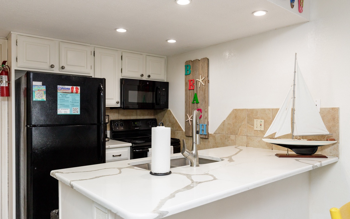 Your beachside kitchen awaits with modern appliances and coastal charm, perfect for preparing meals during your getaway.