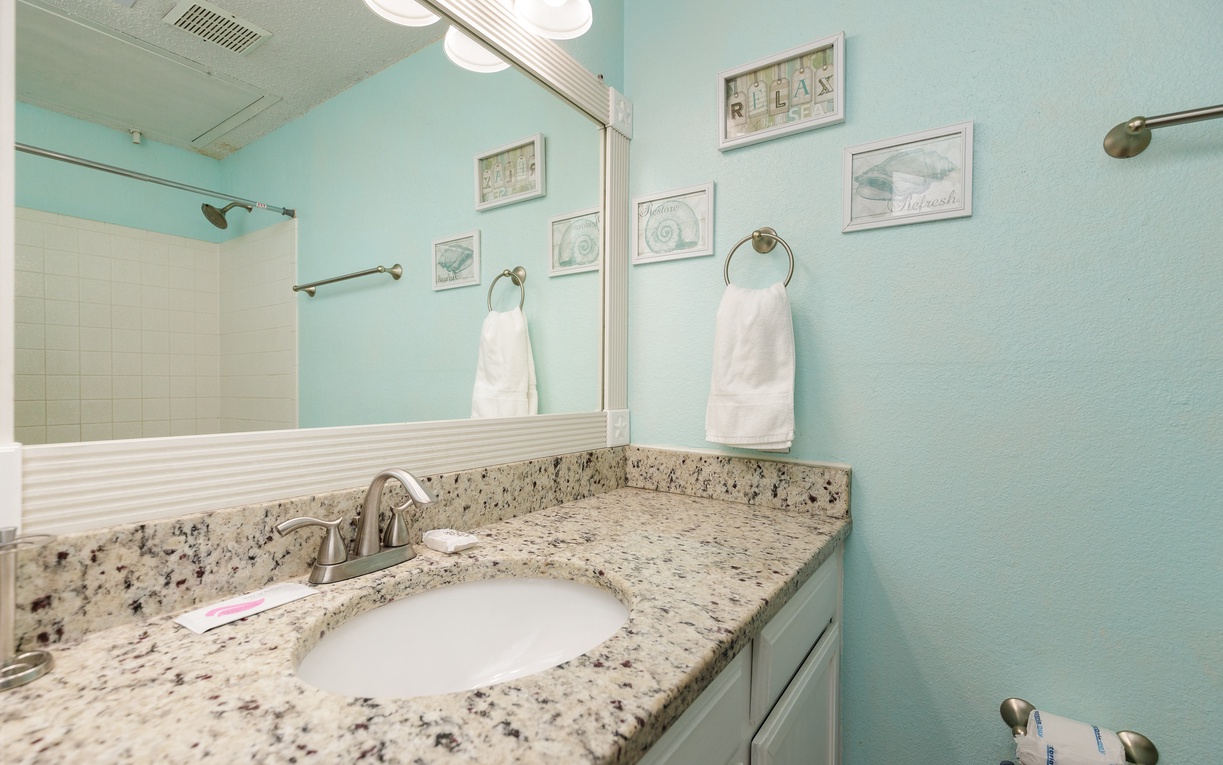 Refresh in your serene bathroom with granite countertops, soft mint walls, and plush towels ready for your comfort.