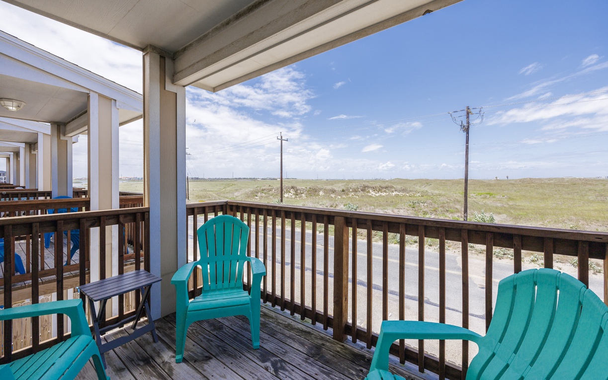 Relax on your private deck with turquoise Adirondack chairs, taking in peaceful grassland views under endless blue skies.