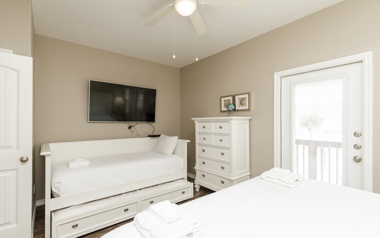 Relax in your primary bedroom with a king size bed, two twin beds, flat-screen TV, and private balcony access for morning coffee or evening unwinds.