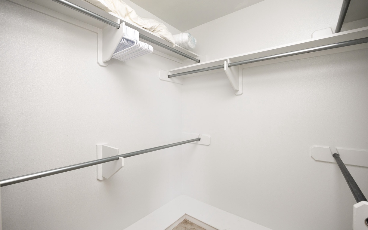 Your spacious walk-in closet offers abundant storage with multiple hanging rods and shelving for organizing your belongings throughout your stay.