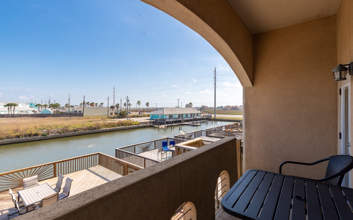 Your private waterfront balcony overlooks a peaceful canal with boat docks, perfect for morning coffee while watching boats glide by.