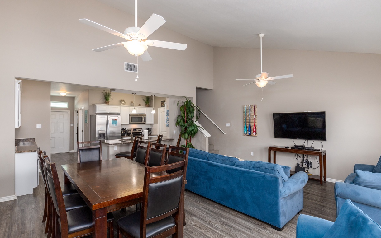 Relax in your spacious open-plan living area with comfortable blue sofas, dining for eight, and a fully equipped kitchen.