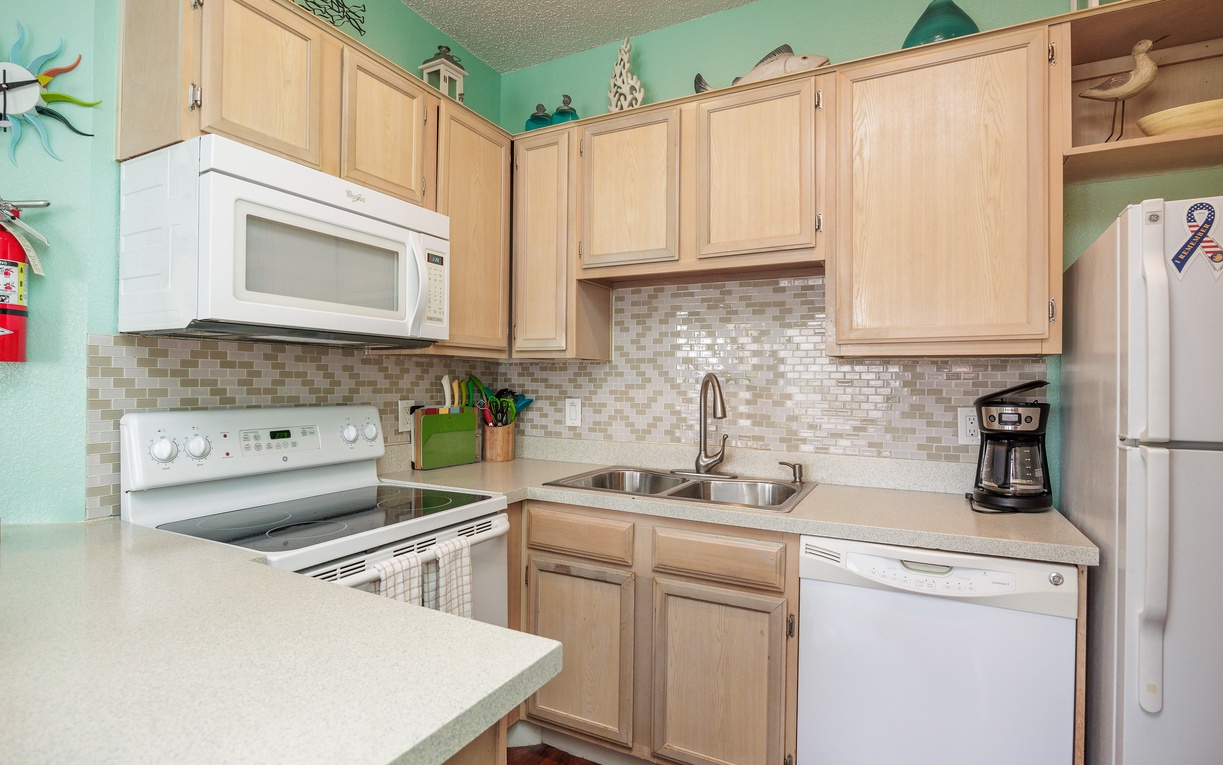 Whip up your favorite meals in this bright kitchen with modern appliances, charming coastal decor, and everything you need for a comfortable stay.