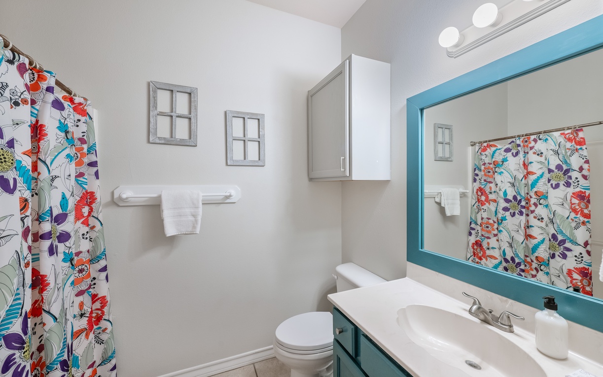 Your private bathroom features cheerful floral accents and turquoise details, creating a bright, welcoming space for your daily routines.