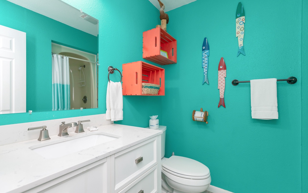 Dive into your own ocean oasis with vibrant turquoise walls, playful fish décor, and coral storage boxes that bring coastal charm to your morning routine.