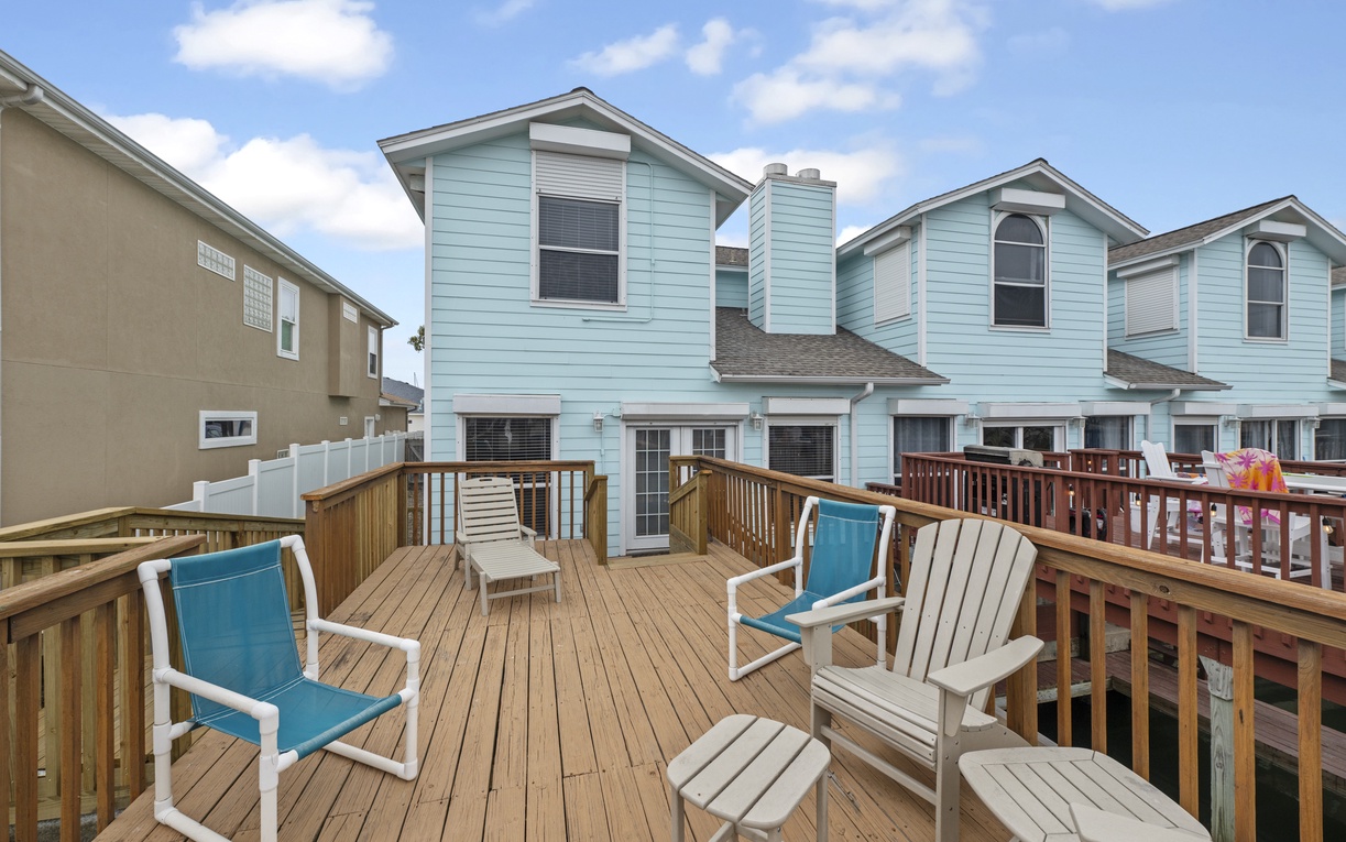 Relax on your private deck with comfortable seating while enjoying the coastal breeze and charming neighborhood views.
