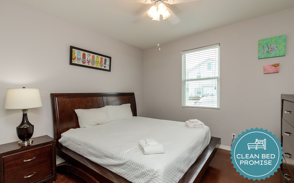 Unwind in your comfortable bedroom featuring a plush queen bed, crisp linens, and natural light streaming through the window.