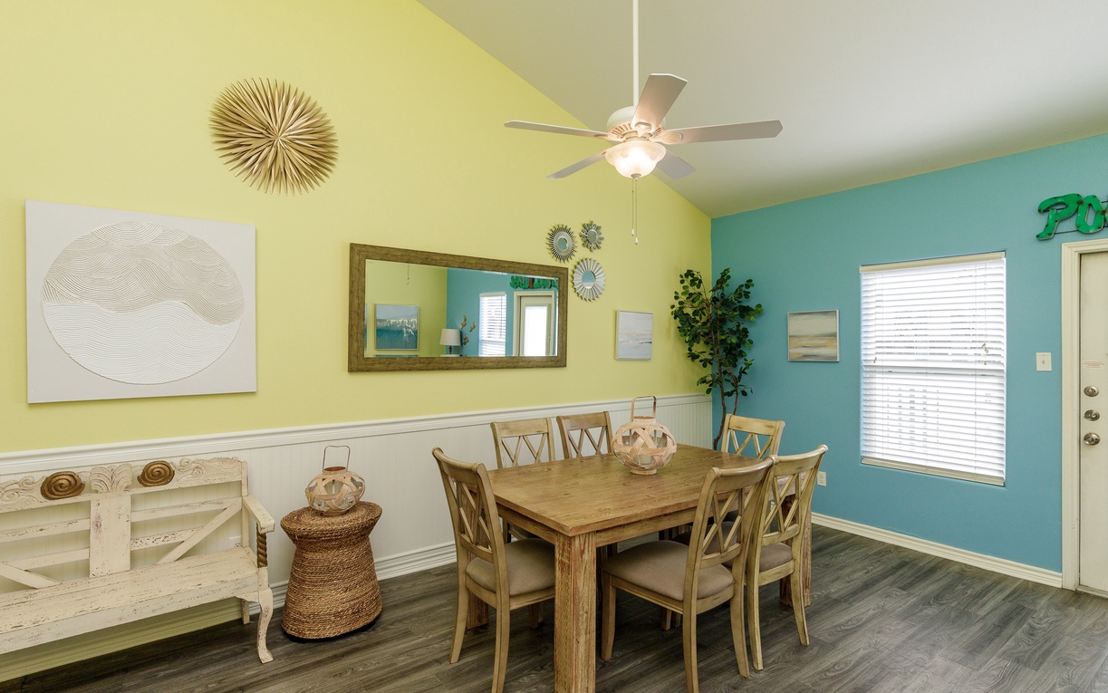 Gather around this bright dining space where cheerful yellow and turquoise walls create a welcoming atmosphere for your family meals and conversations.