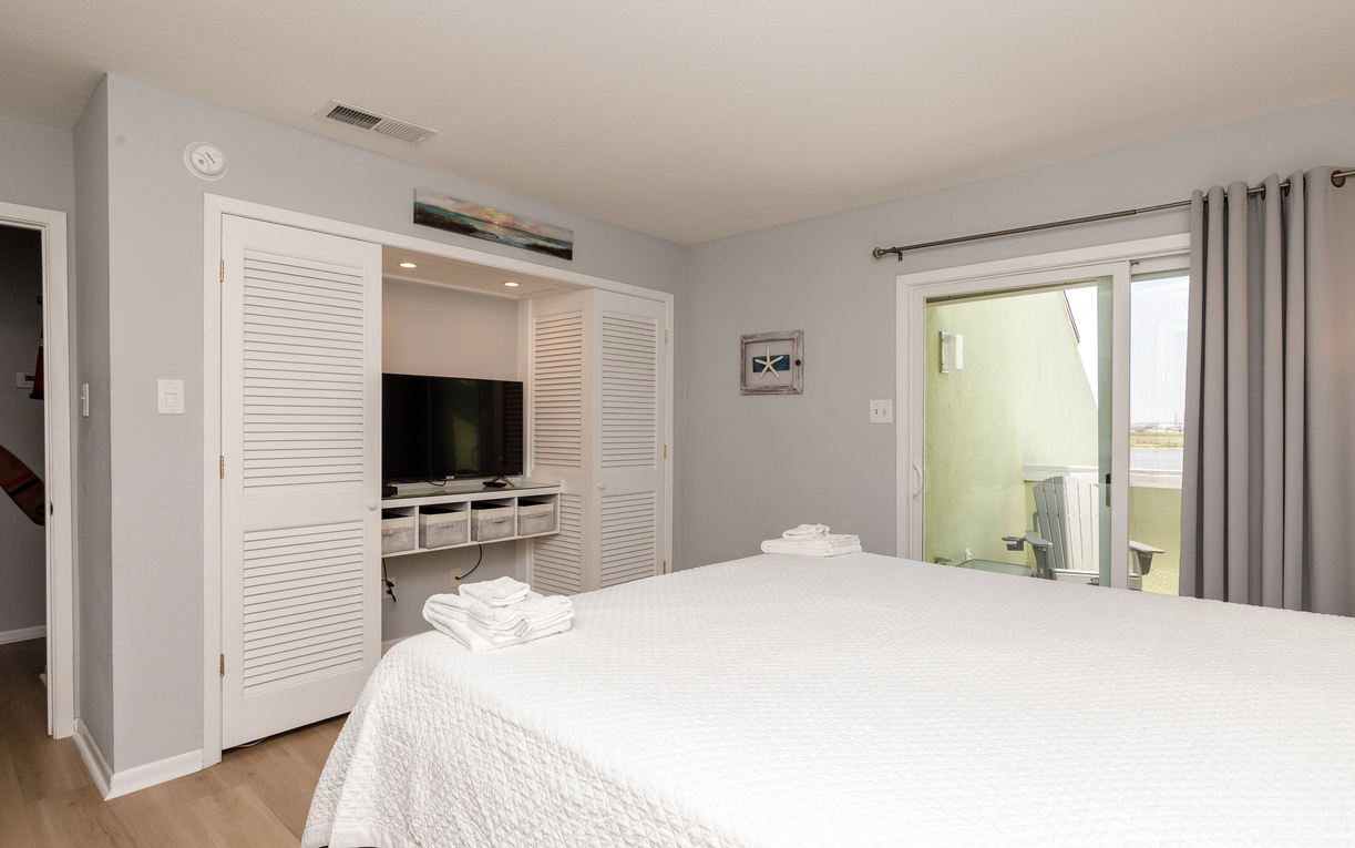 Your serene bedroom features crisp white linens, smart built-in storage with entertainment center, and private balcony access for morning coffee moments.