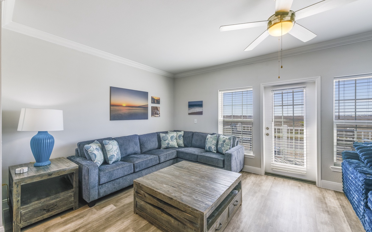 Unwind in your spacious living room with comfortable sectional seating and coastal decor, while French doors open to your private balcony.