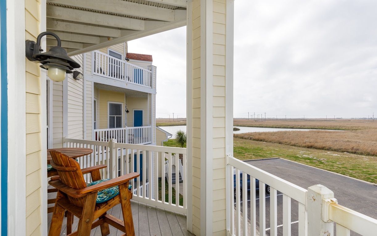 Sip your morning coffee on this peaceful covered balcony overlooking open marshlands and distant coastal views.