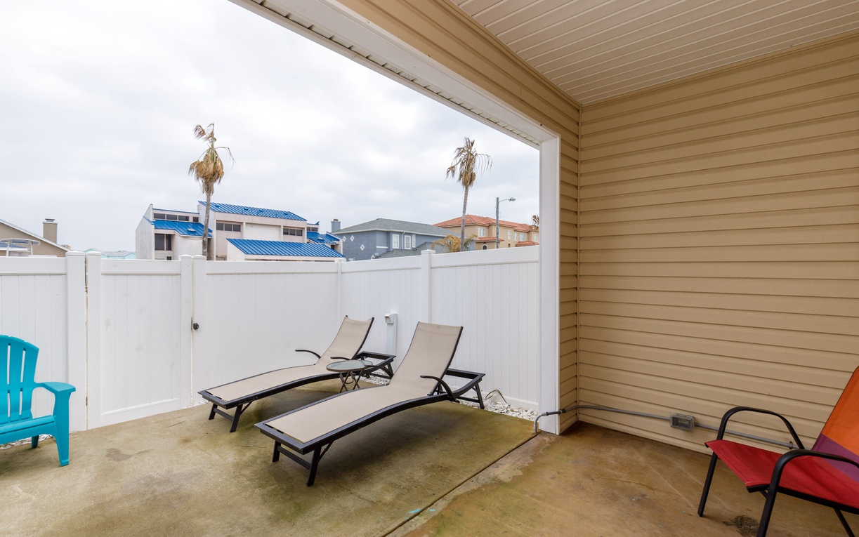 Relax on your private covered patio with comfortable loungers and colorful seating, perfect for morning coffee or afternoon rest.