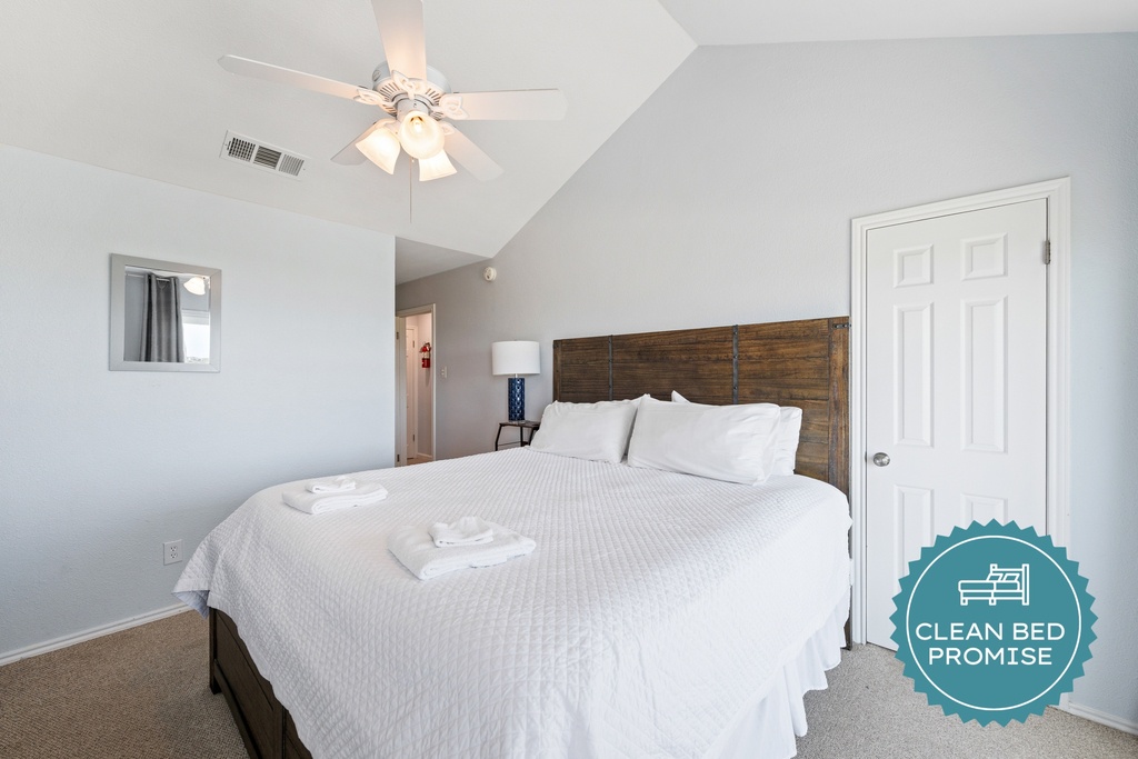 Primary bedroom with a comfortable king bed, vaulted ceiling, and a bright, relaxing coastal feel.