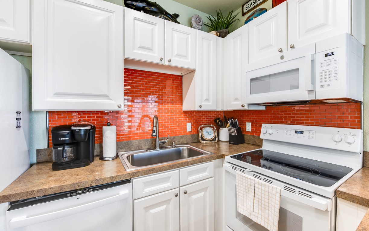 Your fully equipped kitchen features bright orange subway tile, white cabinets, and everything you need to create delicious meals during your stay.