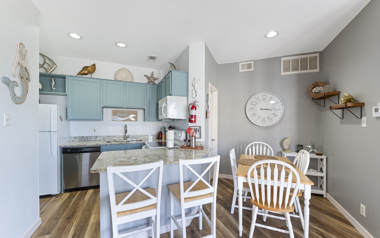 Your charming coastal kitchen features teal cabinets and granite counters, perfect for preparing beachside meals together.
