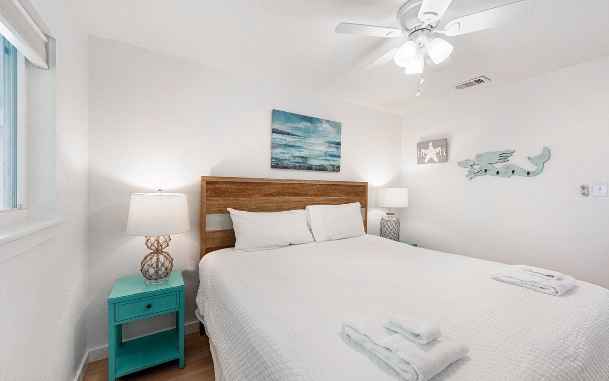 Drift off in your coastal-inspired bedroom, where ocean artwork and turquoise accents create a soothing sanctuary for restful nights.