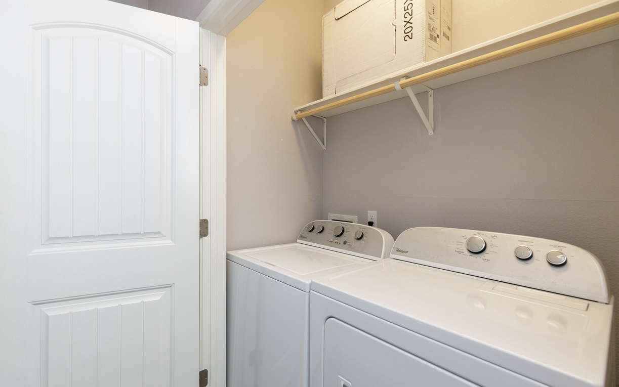Keep your clothes fresh in this convenient laundry room with full-size washer and dryer, plus extra storage above.