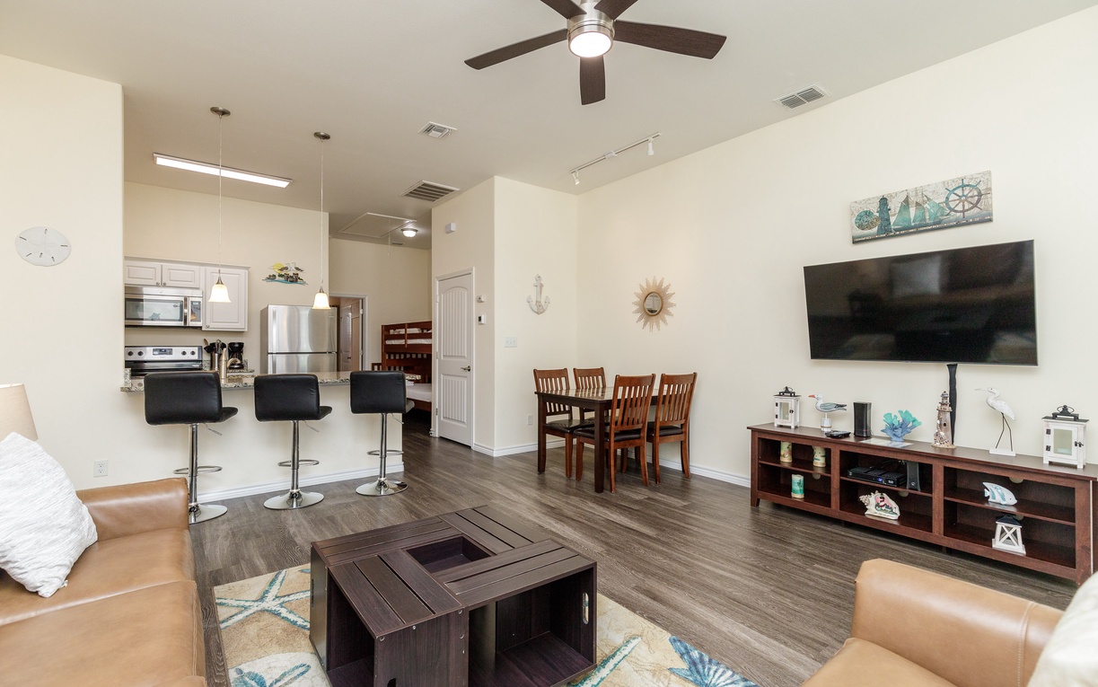 Relax in your spacious living area with leather seating, entertainment center, and open kitchen - perfect for memorable vacation moments together.